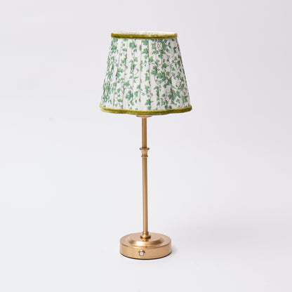 Table lamp with a green floral patterned shade on a white background